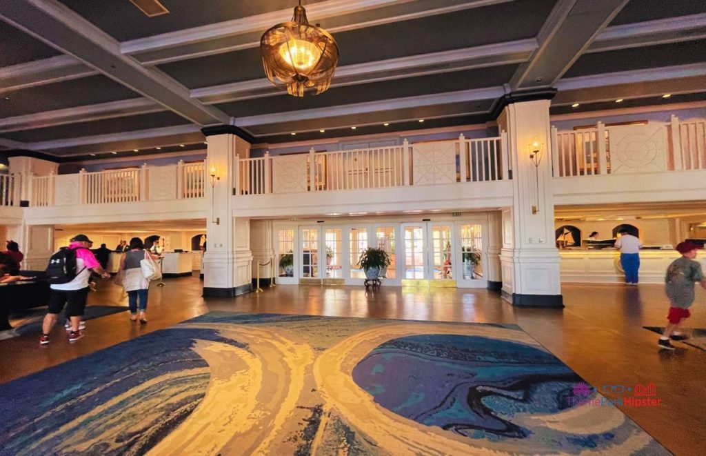 Yacht Club Resort Walt DIsney World lobby area with guests and balcony. Keep reading to find out the most romantic resorts for couples at Walt Disney World.  