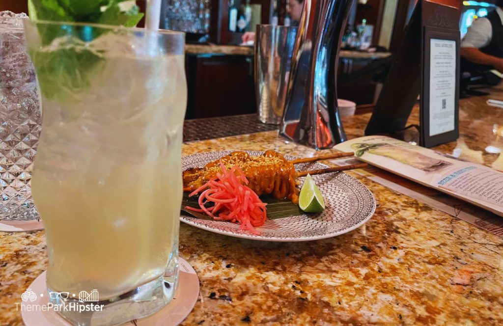 Nomad Lounge at Disney's Animal Kingdom Theme Park Grilled Chicken Satay and Snow Leopard Salvation Cocktail Drink. One of the best bars and lounges at Disney World.