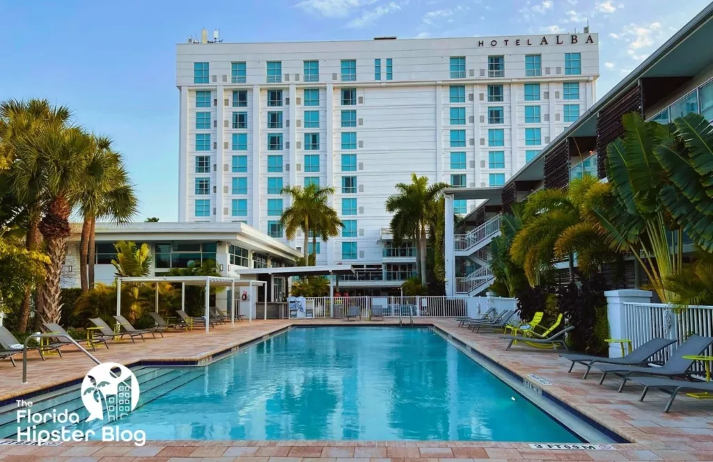 Hotel Alba Tampa pool area with tropical plants and sun loungers. Keep reading to learn more about the best hotels near Busch Gardens Tampa.