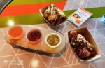 2023 Epcot Food and Wine Festival at Disney Odyssey Cider Flight with Parmesan and Peanut Butter and Jelly Chicken Wings