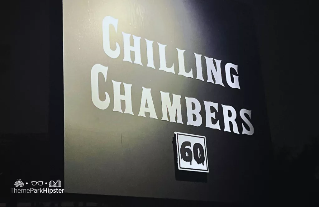 Chilling Chambers house entrance black and white sign with a 60 minute wait time sign at the 2023 Knott's Scary Farm at Knott's Berry Farm in California. Keep reading to learn more about Knott’s Scary Farm 2023 mazes.