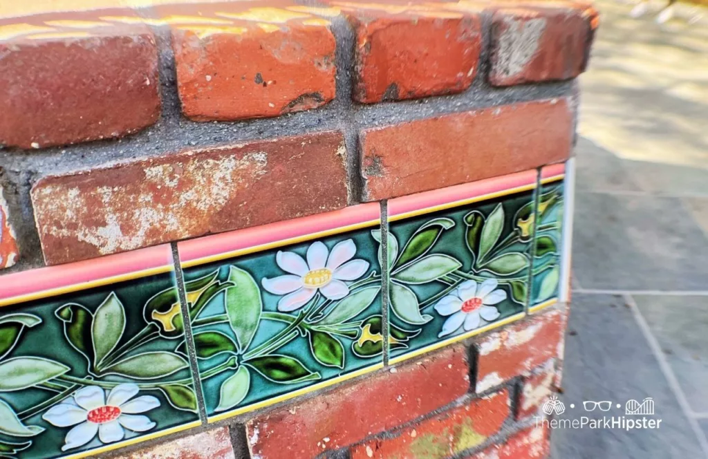 Princess and the Frog Tiana's Palace Restaurant at Disneyland exterior wall with ceramic floral tiling and colorful flowers. Keep reading to find out more about Tiana’s Palace Disneyland.