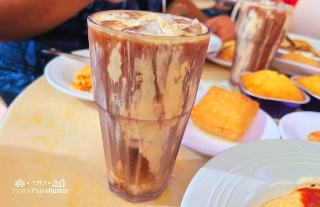 Princess and the Frog Tiana's Palace Restaurant at Disneyland with a tall glass of Joffrey's Coffee Chicory Cold Brew Shake on the table.Keep reading to find out more about Tiana’s restaurant Disneyland.  